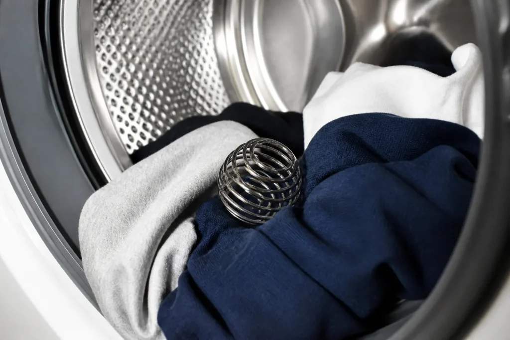 Boule metallique dans tambour seche-linge avec vetements