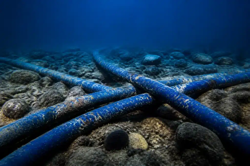 Câbles sous-marins bleus entrecroisés sous l'océan sombre