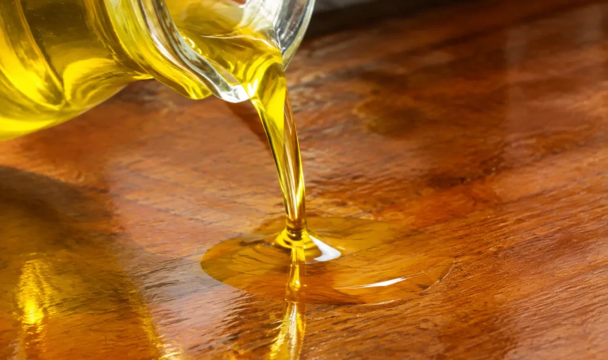 Liquide jaune versé sur surface bois brillante