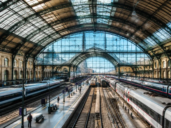 Immense gare avec dome imposant et multiples voies ferroviaires