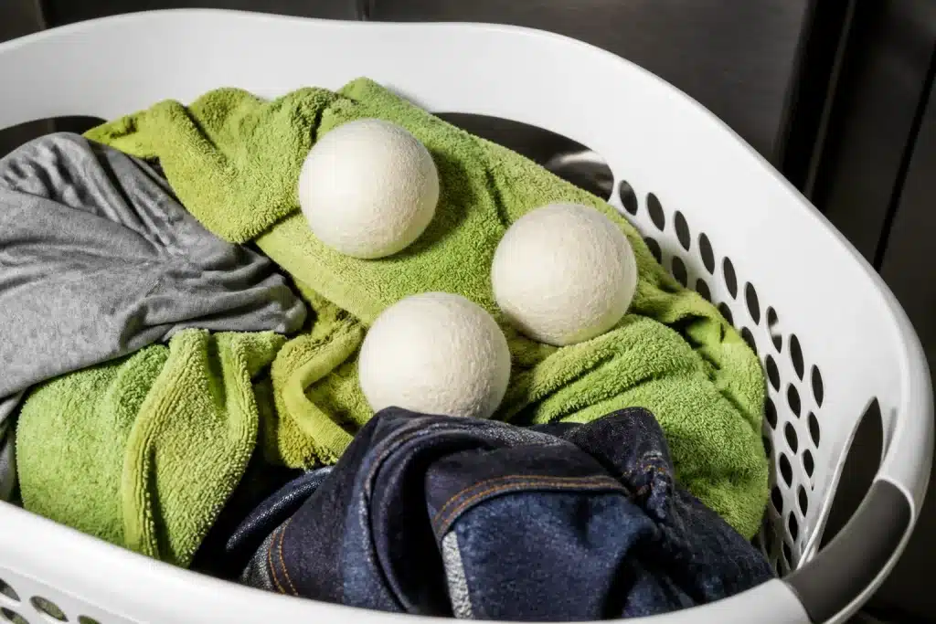 Linge humide avec balles de séchage dans panier blanc