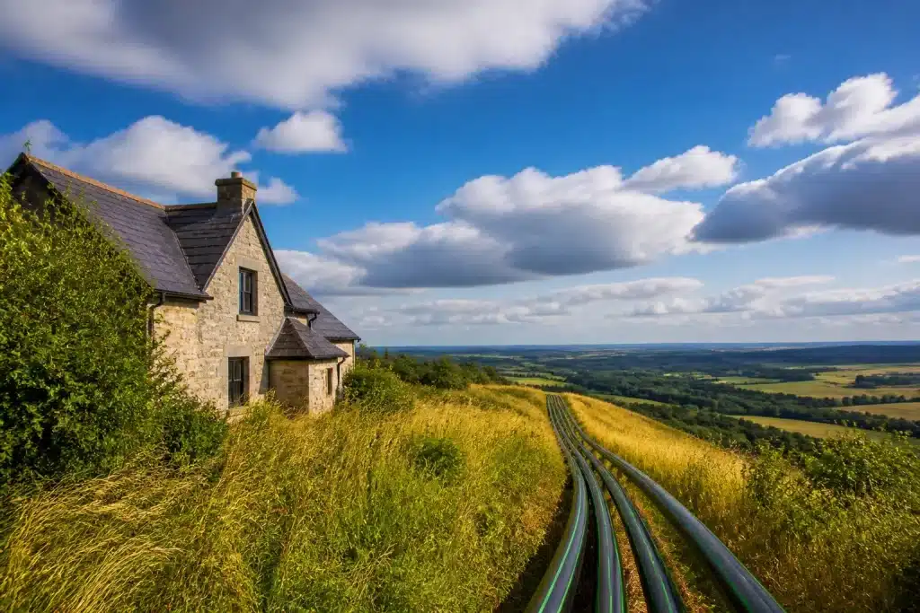 Maison isolée rurale avec câbles de fibre optique s'étendant vers l'horizon