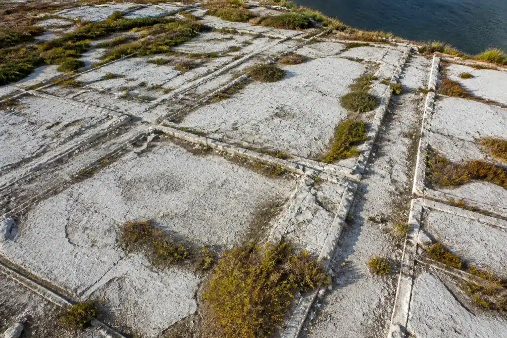 Ruines couvertes de béton blanc avec fissures formant lignes de rues anciennes
