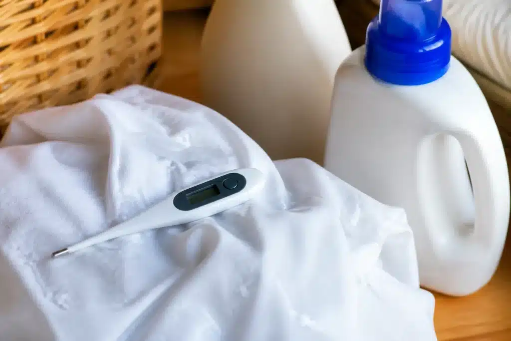 Thermometre pres de detergent et linge humide blanc