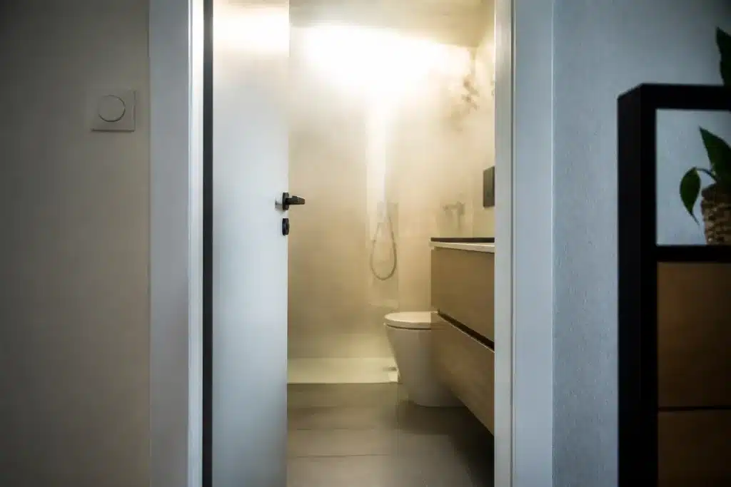 Porte ouverte de salle de bain avec vapeur visible
