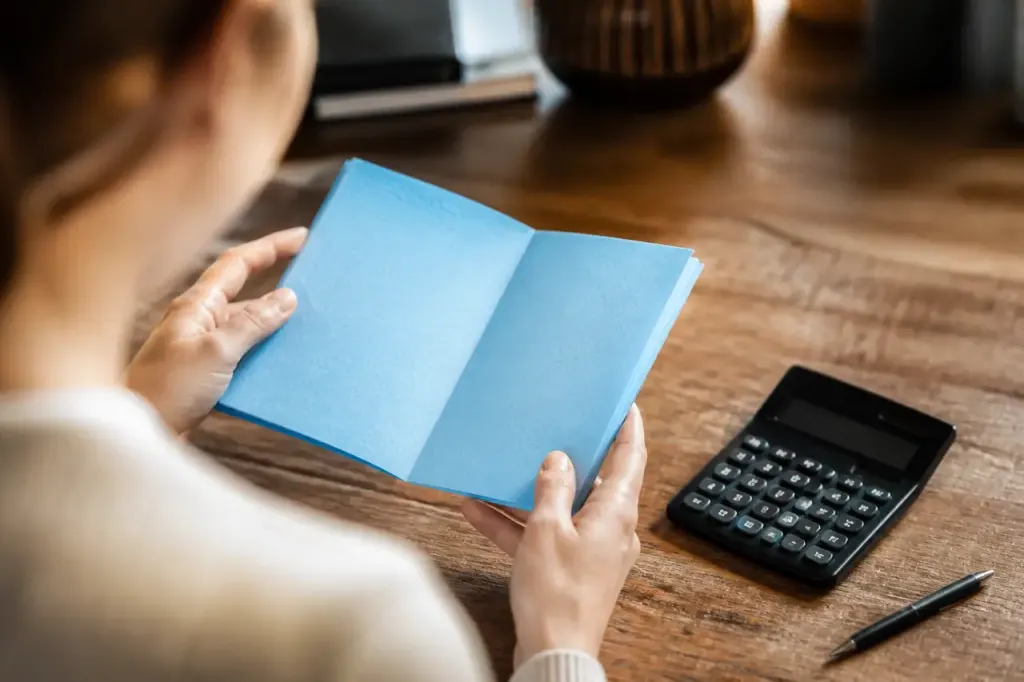 Carnet bleu ouvert sur un bureau avec calculatrice