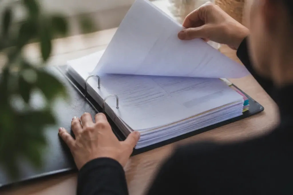 Classeur ouvert rempli de factures et bulletins de paie