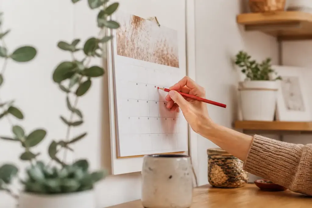 Femme notant une date sur un calendrier mural