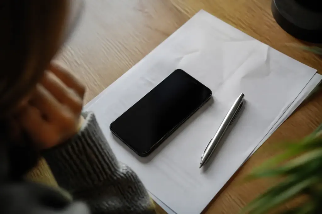 Smartphone et stylo poses sur une facture papier