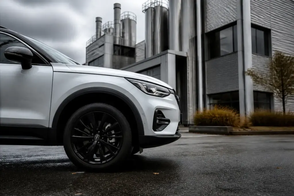 SUV blanc stationne devant usine moderne sous ciel gris
